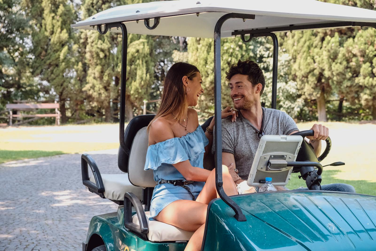 Smilende par i en golfbil i Parco Giardino Sigurtà