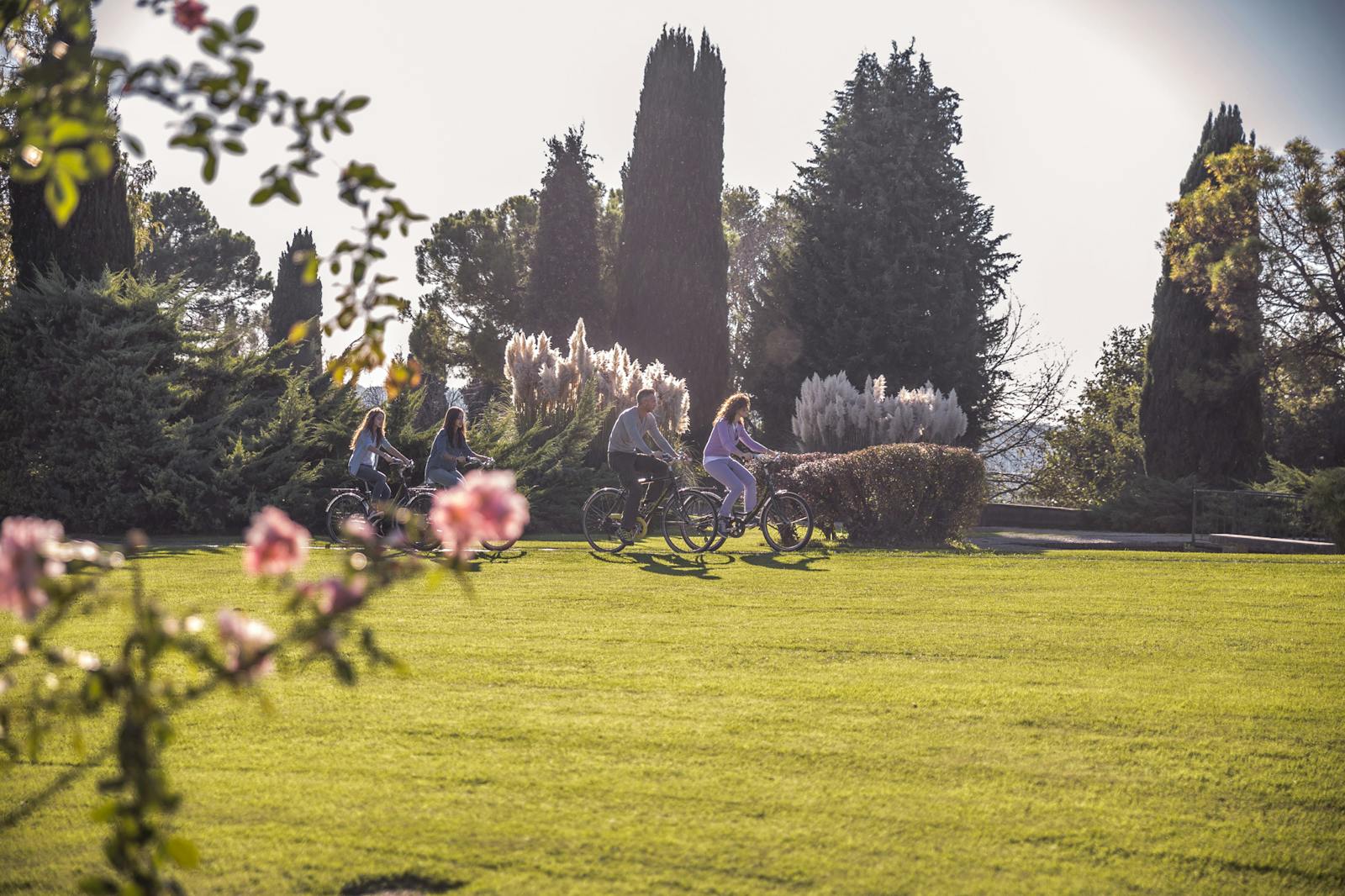 Syklister som krysser Parco Giardino Sigurtà i sollys